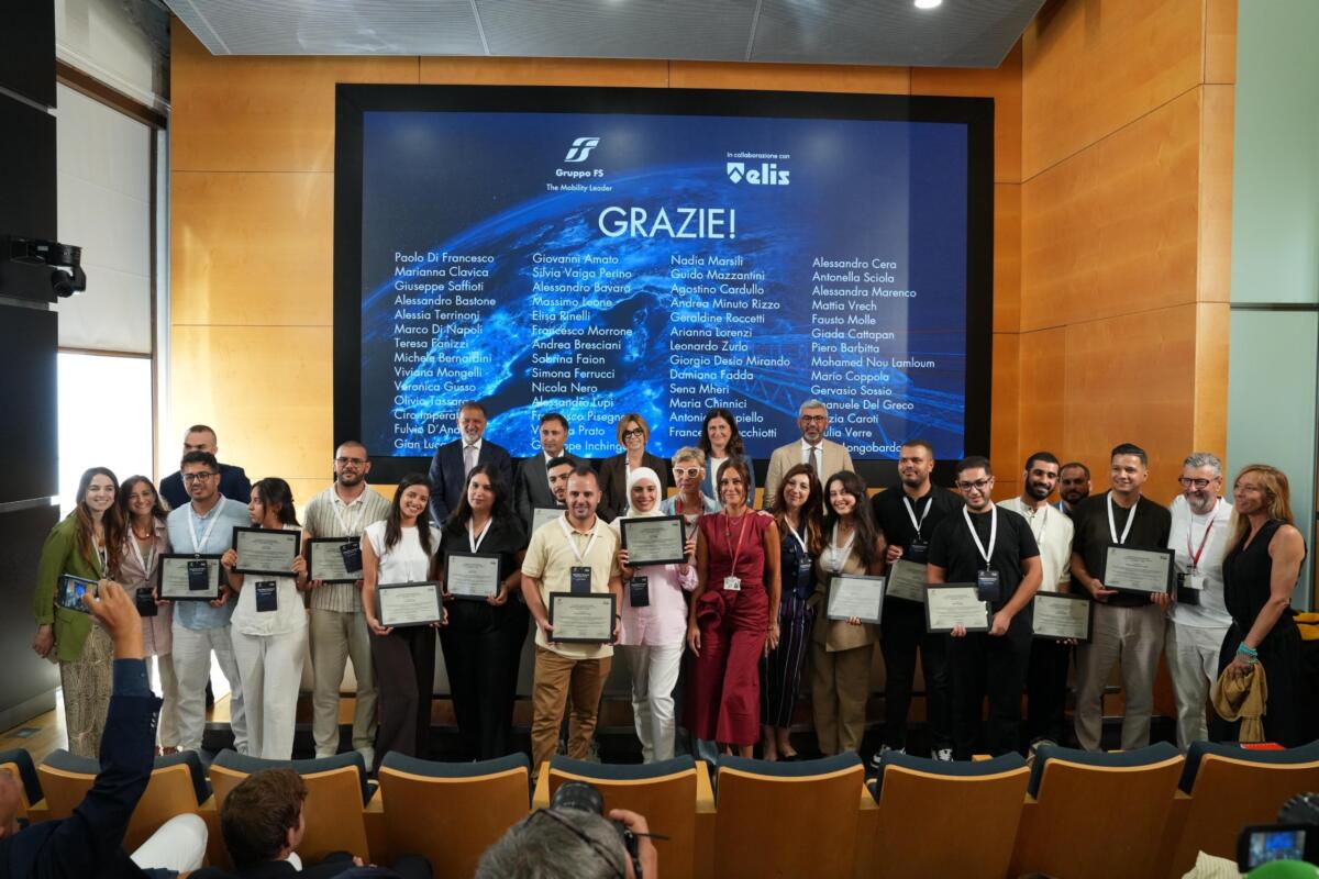Quattordici cittadini tunisini hanno iniziato la propria esperienza professionale in Trenitalia dopo un percorso formativo svolto nel Paese nordafricano. Il progetto costituisce uno dei primi risultati delle iniziative che il Gruppo FS ha sviluppato nell’ambito del Piano Mattei e che ha presentato a Roma, nella sede di Villa Patrizi, durante la cerimonia ‘Benvenuti in Italia – Piano Mattei Tunisia’. Il programma ha unito preparazione linguistica, educazione civica, sicurezza sul lavoro e addestramento tecnico. I partecipanti hanno seguito oltre 400 ore di italiano per raggiungere il livello B2, 150 ore dedicate al ruolo professionale e 24 ore riservate alla sicurezza. Dopo le verifiche sanitarie e amministrative, il gruppo ha raggiunto l’Italia e ha avviato l’inserimento nelle attività di supporto ai servizi ferroviari di Trenitalia. Le assegnazioni riguardano gli impianti di Trieste, Savona, Pisa, Cagliari, Napoli e Taranto. Prima della partenza il progetto ha previsto anche servizi di accompagnamento, potenziamento linguistico e sostegno all’integrazione sul territorio. Il modello tunisino punta su canali regolari di mobilità internazionale e collega la selezione dei candidati a un percorso che prepara sia al mestiere sia alla vita in Italia. La presenza dei tutor aziendali offre inoltre un riferimento durante le prime fasi dell’attività. Lo scopo è un inserimento lavorativo stabile. La cerimonia ha riunito rappresentanti delle istituzioni, del Gruppo FS, di Trenitalia e dell’Ambasciata tunisina. Sono intervenuti Anna Veronica Gianasso, consigliera della Struttura di missione per l’attuazione del Piano Mattei; Giuseppe Inchingolo, Chief Corporate Affairs, Communication & Sustainability Officer del Gruppo FS; Gian Luca Orefice, Chief People, Culture & Transformation Officer; Francesca Stacchiotti, direttrice Risorse umane e Organizzazione di Trenitalia; Mohamed Amine Sayeb, consigliere politico dell’Ambasciata della Repubblica di Tunisia a Roma. “Sfida strategica” “Il Piano Mattei rappresenta una sfida strategica per costruire una cooperazione fondata su competenze, crescita condivisa e sviluppo sostenibile” le parole di Giuseppe Inchingolo. Il manager ha ricordato che il Gruppo FS mette a disposizione patrimonio industriale, tecnologia e professionalità, con l’obiettivo di rafforzare il dialogo tra Italia e Africa. “I progetti realizzati in Tunisia ed Egitto dimostrano come un grande gruppo industriale possa contribuire concretamente agli obiettivi del Sistema Paese”, ha aggiunto. Gian Luca Orefice ha richiamato il ruolo della qualificazione professionale: “La formazione è il punto di partenza imprescindibile per costruire percorsi di inserimento lavorativo efficaci e duraturi”. Secondo il responsabile People, Culture & Transformation, il progetto combina competenze, inclusione e crescita professionale e crea le condizioni per un’integrazione basata sul lavoro e sulla condivisione delle conoscenze: “Un approccio che riflette pienamente i valori e la cultura del Gruppo FS, fondati sulla centralità delle persone, sullo sviluppo delle competenze e sulla capacità di trasformare il talento in opportunità di crescita condivisa”. Francesca Stacchiotti ha posto l’attenzione sul passaggio dalla formazione all’attività in azienda: “Il percorso avviato dal nostro Gruppo nell’ambito del Piano Mattei dimostra come gli investimenti nella formazione possano tradursi in opportunità concrete di lavoro e di crescita professionale”, ha spiegato. “Con l’ingresso in Trenitalia si apre una nuova fase, nella quale le competenze acquisite incontrano l’esperienza operativa e diventano parte integrante della nostra organizzazione”. Le strutture aziendali seguiranno il percorso e sosterranno l’integrazione dei nuovi lavoratori. Acquisizioni di competenze Il contributo del Gruppo FS al Piano Mattei comprende anche una linea di intervento in Egitto. Gli esperti di FS Engineering hanno curato un programma tecnico per docenti e studenti di istituti professionali locali. Le attività hanno riguardato la modernizzazione dei sistemi di segnalamento e controllo, la manutenzione dell’infrastruttura ferroviaria, la transizione energetica e l’adozione di nuove tecnologie. Il programma ha coinvolto gli istituti salesiani Don Bosco del Cairo e di Alessandria, con moduli rivolti agli insegnanti e a circa 60 studenti. Il confronto con gli specialisti di FS Engineering ha favorito l’acquisizione di competenze spendibili nel mercato del lavoro locale e ha consolidato la collaborazione tra i due Paesi nel settore ferroviario e infrastrutturale. Le iniziative in Tunisia ed Egitto seguono due direttrici complementari. La prima collega formazione e occupazione nel sistema ferroviario italiano; la seconda trasferisce conoscenze tecniche ai territori di origine. Entrambe si inseriscono nella cooperazione promossa dal Sistema Paese e vedono la collaborazione di ELIS, ente non profit attivo nell’orientamento, nella formazione e nell’innovazione tecnologica.